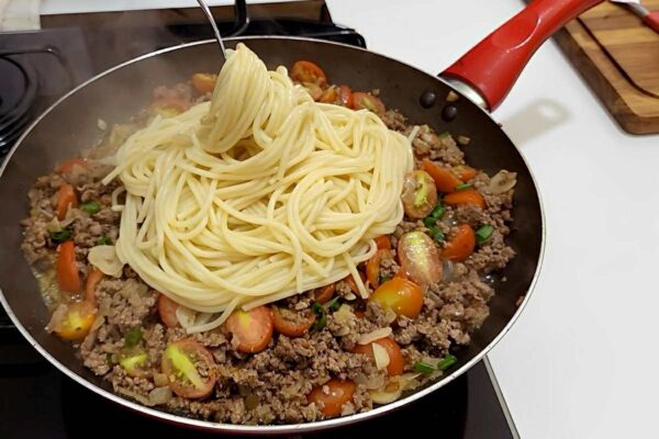 Pasta en mantequilla con carne de tierra y tomar un placer